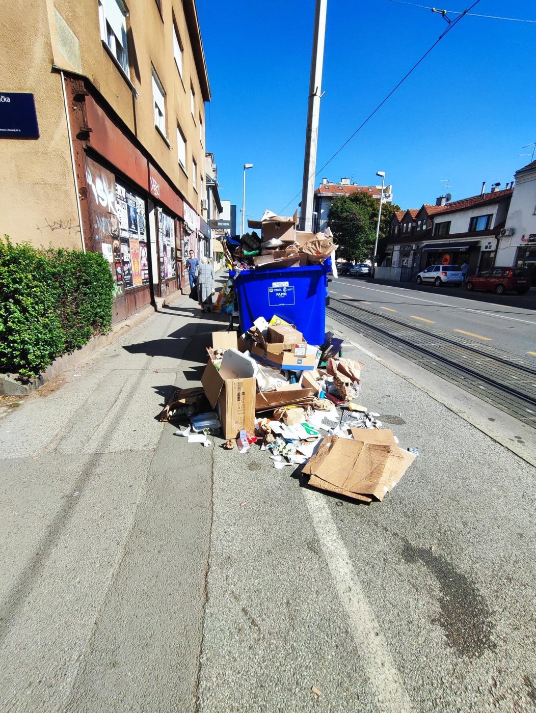 Prepuni spremnik za papir i rasuti karton uz tramvajske tračnice